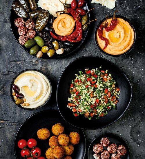 Arabische Küche. Orientalische Meze-Platte mit Fladenbrot, Oliven, Hummus, gefüllten Dolma, Labneh Käsebällchen in Gewürzen. Mediterrane Vorspeise Partyidee