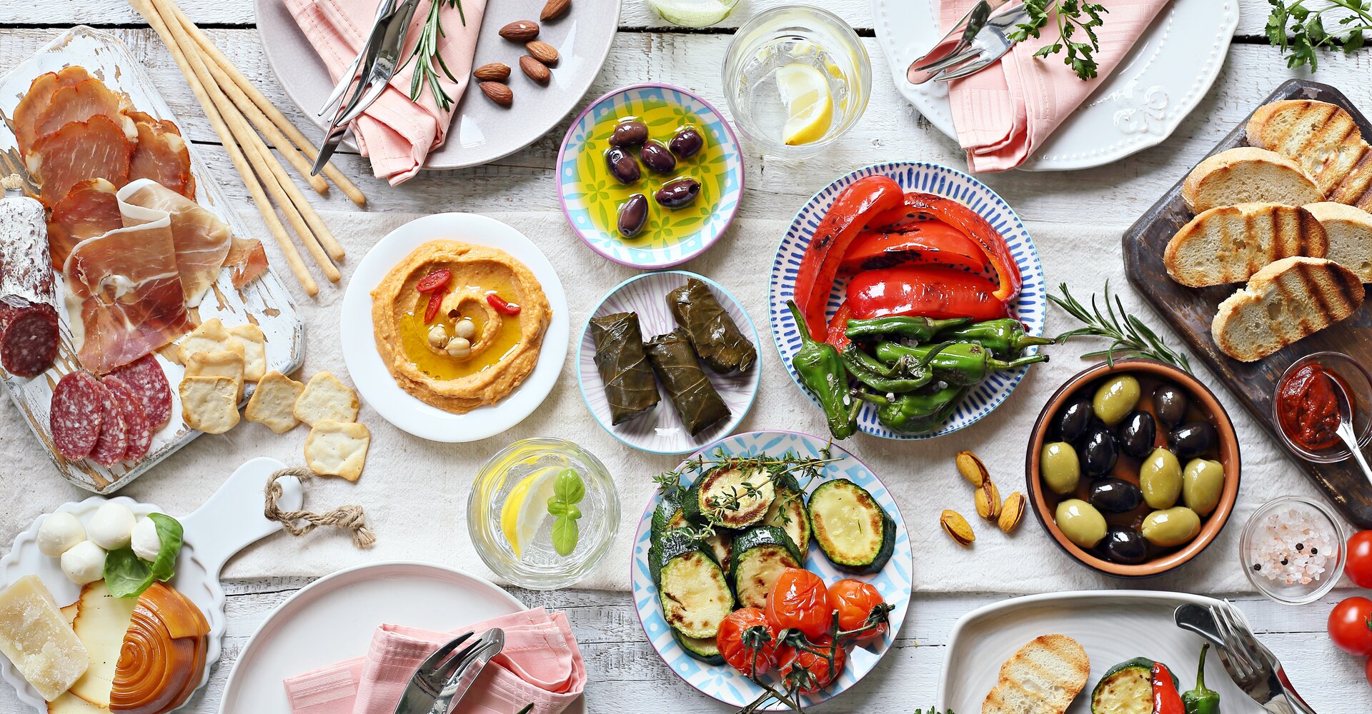 Mediterrane Vorspeisen Tischkonzept. Diner Tisch mit Antipasti Auswahl: gegrilltes Gemüse,  Wurstwaren, Fleisch und Wurstwaren, Schinken, Oliven, Käse, Hummus und geröstetem Brot.